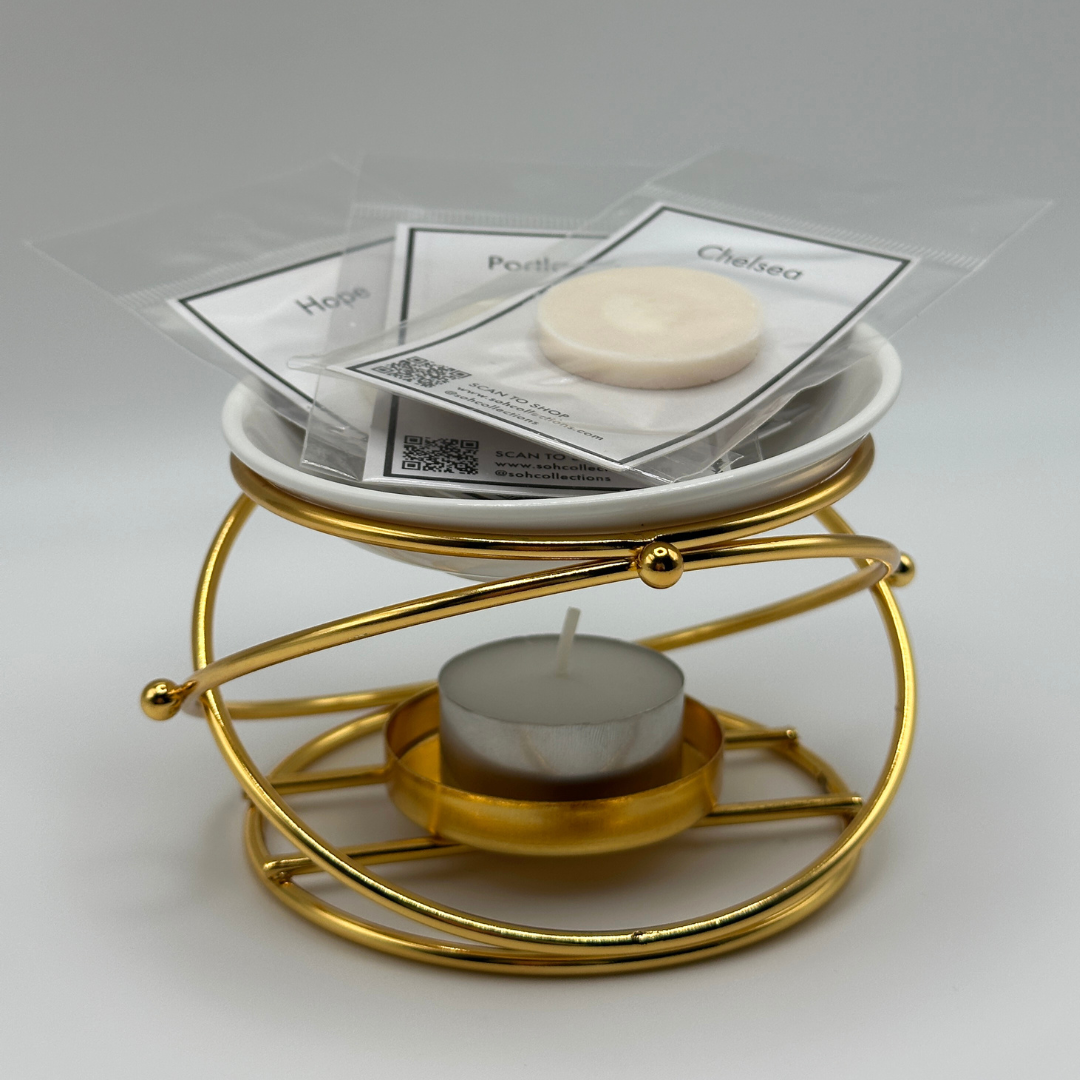 Gold-toned brushed gold wax melt burner with white ceramic dish and wax melts